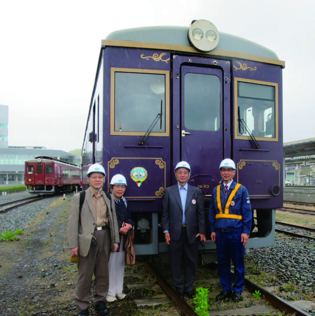 Commemorative photo with the Kuwaiti train in the background at the rail yard. President Ishikawa himself took the picture so that the Kuwaiti national emblem, which is engraved on the front left side of the car, could be seen. From right to left: Mr. Junichi Konno, General Manager of Operations, the author, Mrs. Kobayashi, and Mr. Kobayashi, Chairman of the Board of Salaam.