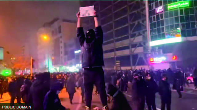 首都テヘラン北西部のカージ広場での抗議行動。抗議者の1人が、1979年のイスラム革命で追放されたかつての国王の息子で、現在はアメリカで暮らすレザ・パーレヴィ元皇太子の写真を掲げている（9日）（写真キャプションはBBC NEWS Japan 2026年1月13日）